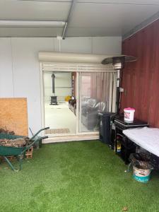 ein Zimmer mit grünem Gras und einer Glasschiebetür in der Unterkunft GoGolan in Madschdal Schams