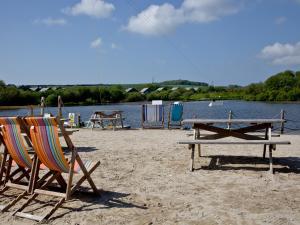 two chairs and a picnic table on a beach at Ash Lodge - Retallack in Saint Columb Major
