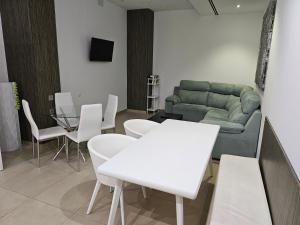 a living room with a couch and white tables and chairs at Gran Hotel Botánicos in Teruel