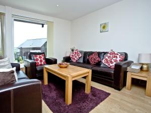 a living room with a couch and a table at Cedar Lodge - Retallack in Saint Columb Major