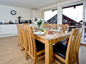 a kitchen and dining room with a wooden table and chairs at Cedar Lodge - Retallack in Saint Columb Major