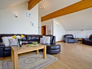 a living room with leather furniture and a coffee table at Cedar Lodge - Retallack in Saint Columb Major +19 photos