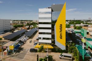 a building with a yellow sign on the side of it at Slim Hotel Cuiabá Aeroporto in Cuiabá