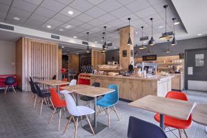 a restaurant with wooden tables and chairs and a counter at ibis De Haan in De Haan