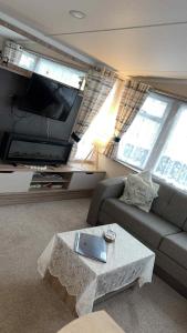 a living room with a couch and a table and a tv at B10 - The Escape Pod in Heysham