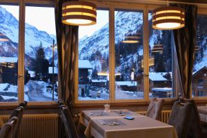 a table in a restaurant with a view of mountains at Hôtel Le Besso - Swiss Romantic Lodge Zinal in Zinal +27 photos