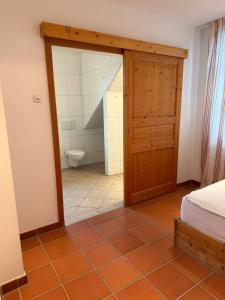 a bedroom with a bathroom with a toilet and a door at Scheune B7 in Düsseldorf