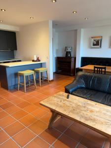 a living room with a couch and a table and a kitchen at Scheune B7 in Düsseldorf