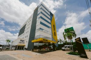 a building with a yellow sign in front of it at Slim Hotel Cuiabá Aeroporto in Cuiabá +46 photos