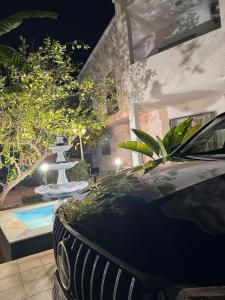 a black car parked next to a fountain at night at Beautiful House in Tunis