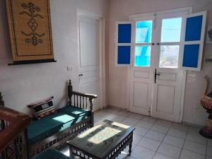 a living room with two benches and a door at Maison Cally in Midoun