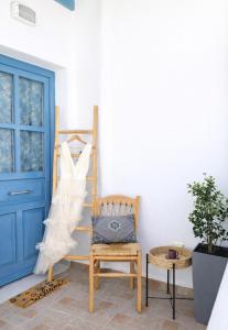 ein Holzstuhl in einem Zimmer mit blauer Tür in der Unterkunft YouGa Nest in Vívlos