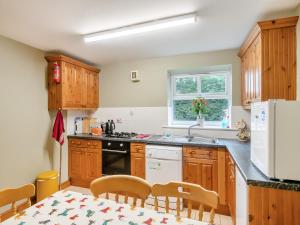 a kitchen with wooden cabinets and a table and chairs at The Hayloft - 17238 in York +26 photos