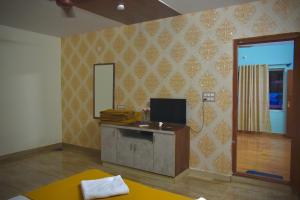 a room with a desk with a television on a wall at Gandhada Goodu Retreat in Kanakapura