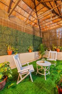 a patio with two chairs and a table at Bougain Blossom Spacez Luxury Villa with Terrace Garden in Bangalore +46 photos
