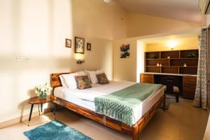 a bedroom with a bed and a desk in it at Bougain Blossom Spacez Luxury Villa with Terrace Garden in Bangalore