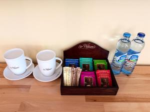 a box of books next to two cups and water bottles at Dymer in Biskupiec