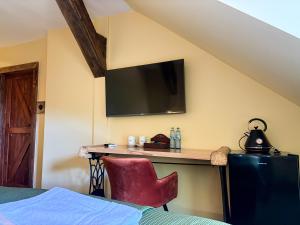 a bedroom with a desk and a television on the wall at Dymer in Biskupiec