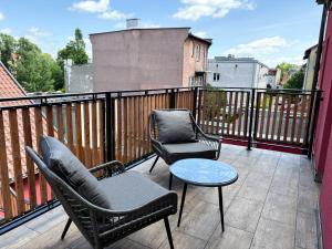 a balcony with two chairs and a table on a balcony at Dymer in Biskupiec