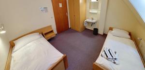 a hospital room with two beds and a sink at Pension Keinath in Stuttgart
