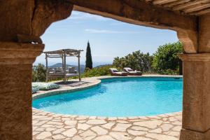 a pool with a gazebo and chairs in a yard at Villa le repaire in Ramatuelle