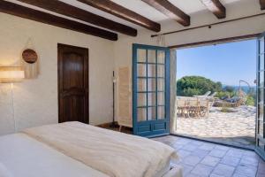 a bedroom with a bed and a large sliding glass door at Villa le repaire in Ramatuelle