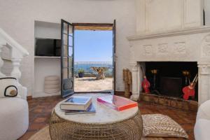 a living room with a table with books on it at Villa le repaire in Ramatuelle +7 photos