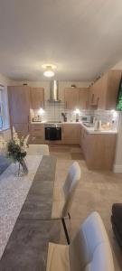 a large kitchen with white chairs and a table at The Mourne Nest in Newcastle