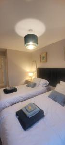 a bedroom with two beds with towels on them at The Mourne Nest in Newcastle
