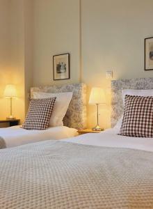 two beds in a room with two lamps on tables at Bed and Breakfast Otentik in Zuienkerke
