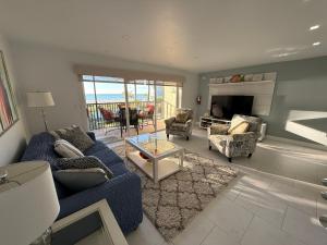 a living room with a blue couch and chairs at Sunset Beach 101 Beach Front Unit in Holmes Beach