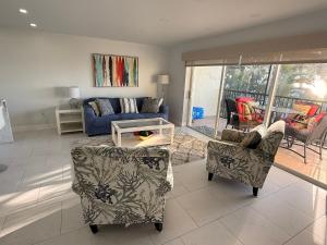 a living room with two chairs and a couch at Sunset Beach 101 Beach Front Unit in Holmes Beach +18 photos