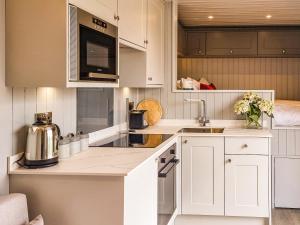 a kitchen with white cabinets and a sink at The Pod - Uk38513 in Babcary