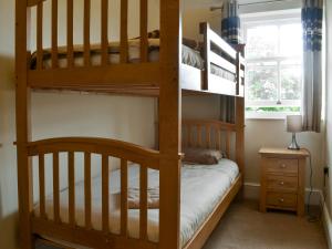 a bedroom with two bunk beds and a window at Raby Cottage-27764 in Wolsingham