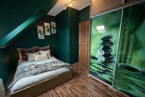 a bedroom with green walls and a bed with a window at Spa Residence beltéri jakuzzi inside jakuzzi in Veszprémfajsz