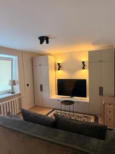 a living room with a couch and a flat screen tv at Apartamenti Ikšķile in Ikšķile