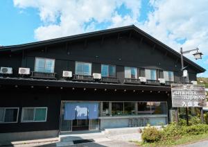 a black building with a sign in front of it at 入山登 in Hakuba