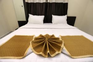 a large bed with a large brown blanket on it at Hotel Bansi Palace in Dwarka