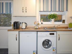 a kitchen with a washing machine and a sink at Mountain View in Blaenau-Ffestiniog