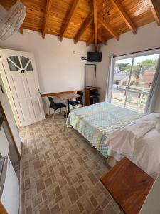 a bedroom with a bed and a table and a window at Complejo Hueney in Mar de Ajó