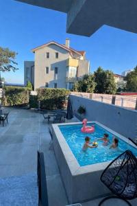 a group of children playing in a swimming pool at MAV Beach Villa in Eforie Nord