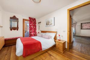 a bedroom with a bed with a red blanket at Maison Carrel Elegant 4 in Breuil-Cervinia