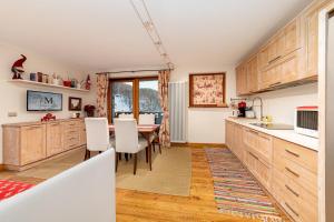 a kitchen with wooden cabinets and a table with white chairs at Maison Carrel Elegant 4 in Breuil-Cervinia