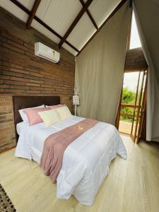 a bedroom with a large bed in a room at Pousada Jardins da Gastehaus in Triunfo