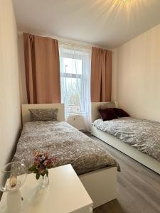 a bedroom with two beds and a table with flowers at Apartment Brunsbüttel 3 in Brunsbüttel