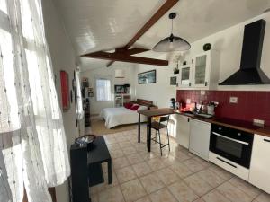 a kitchen and living room with a bed in the background at L'Opaline-Maisonnette 28m2 grand confort avec jardin-tout inclus in Tully