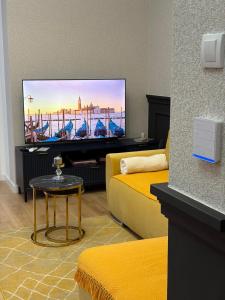 a living room with a tv and a couch and a table at VukAs in Palić