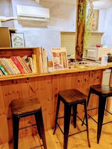 a counter with two stools in front of a counter with books at Kaido Urasa CoLiving in Minami Uonuma +37 photos