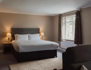 a bedroom with a bed and a couch and a window at Lyzzick in Keswick