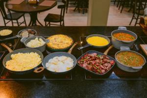 a table topped with bowls of different types of food at Slim Hotel Cuiabá Aeroporto in Cuiabá